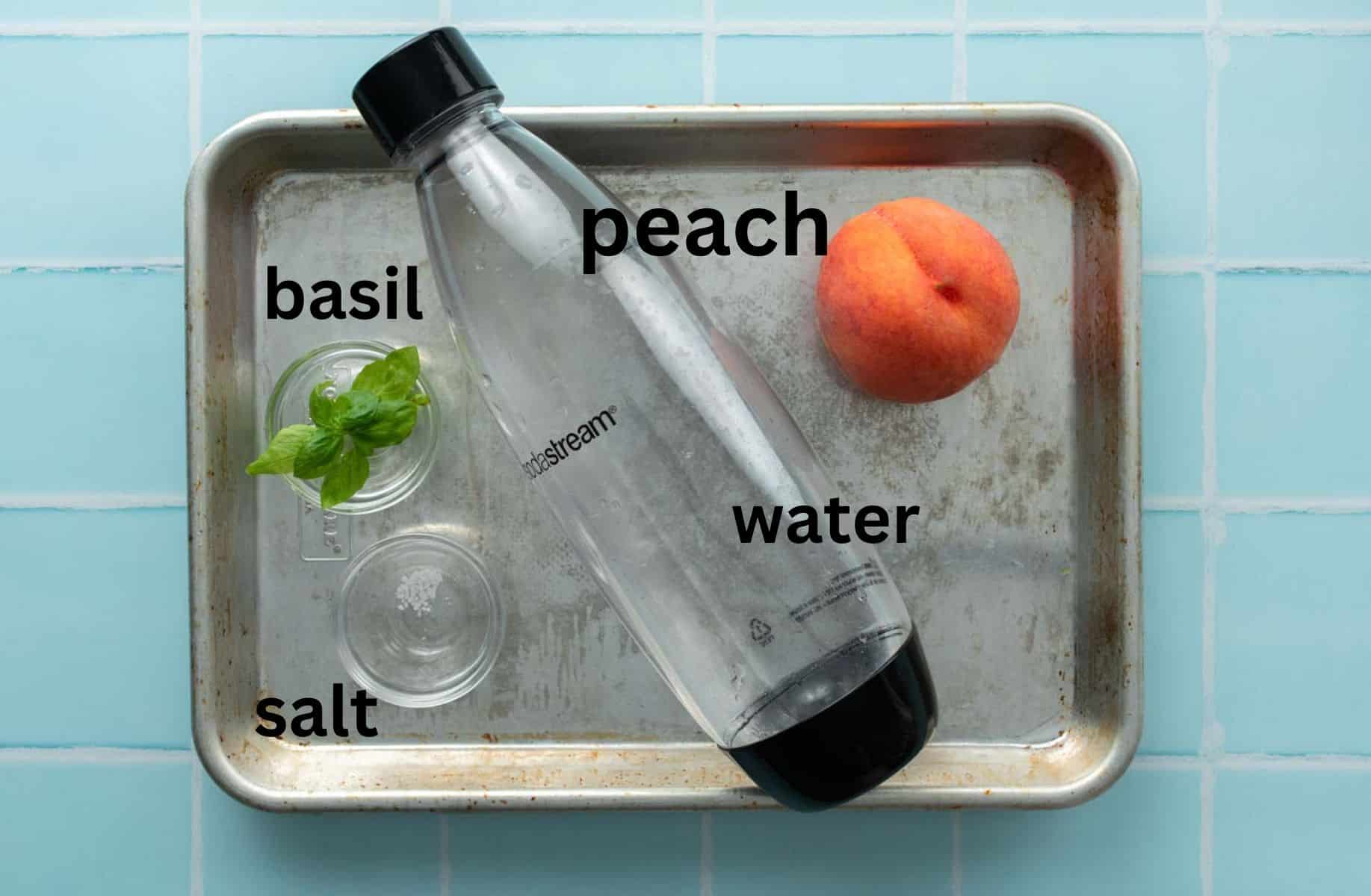 baking sheet with peach, bottle of water, basil, and salt