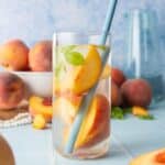 peach slices in water in glass