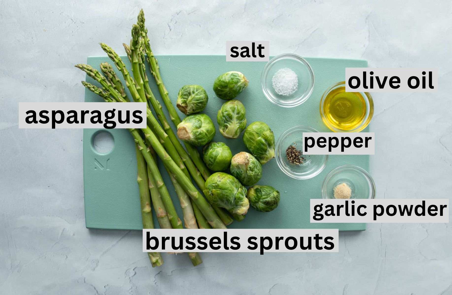 asparagus, brussels sprouts, seasonings and oil on cutting board, with labels