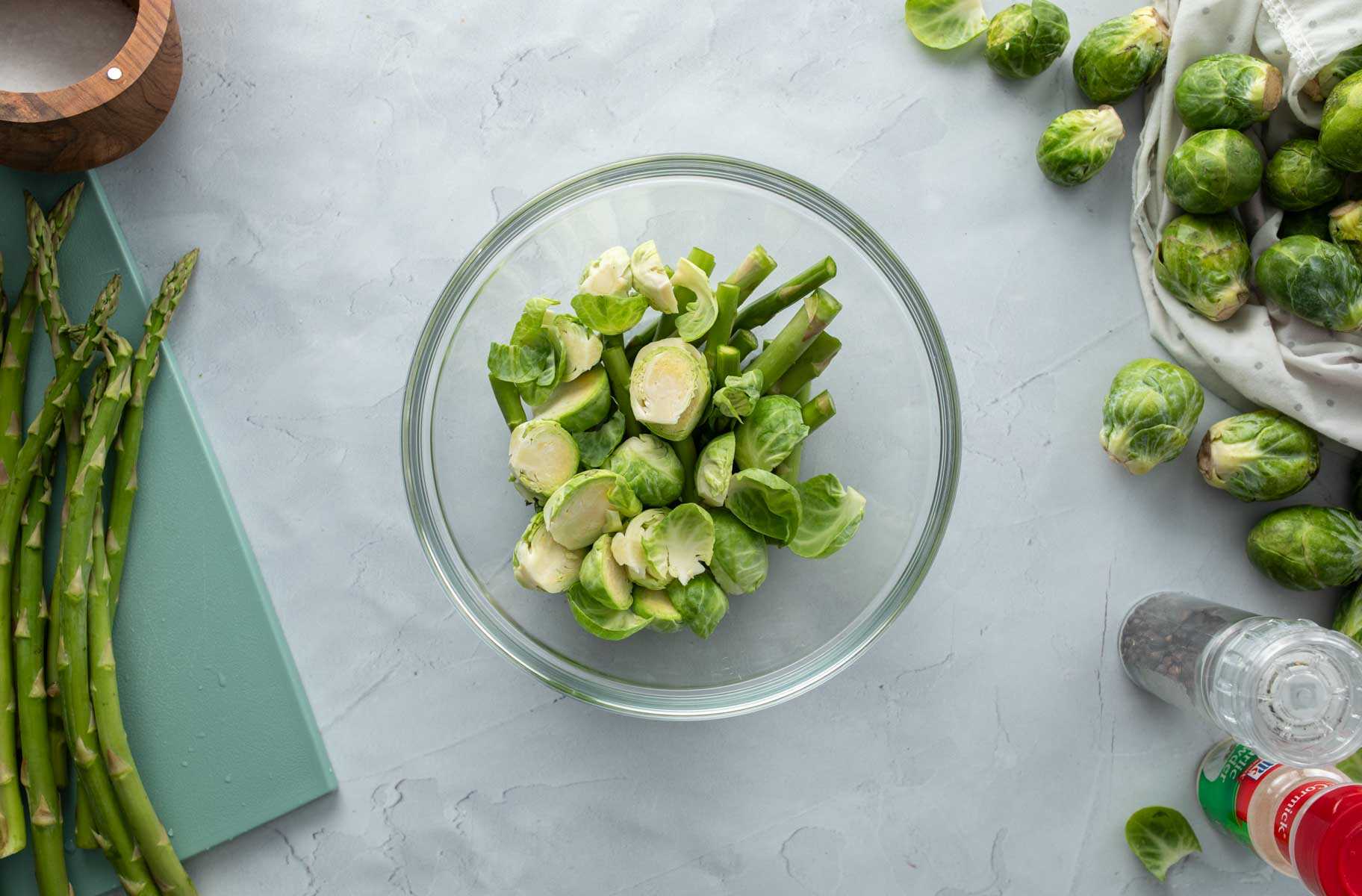 raw sliced brussels sprouts and asparagus in bowl