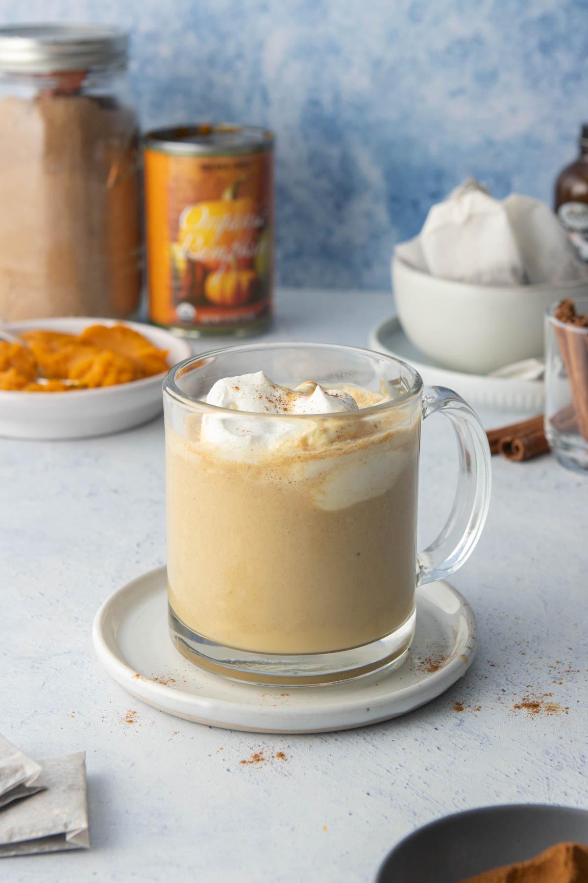 chai latte with pumpkin pie spice in mug, with ingredients in back