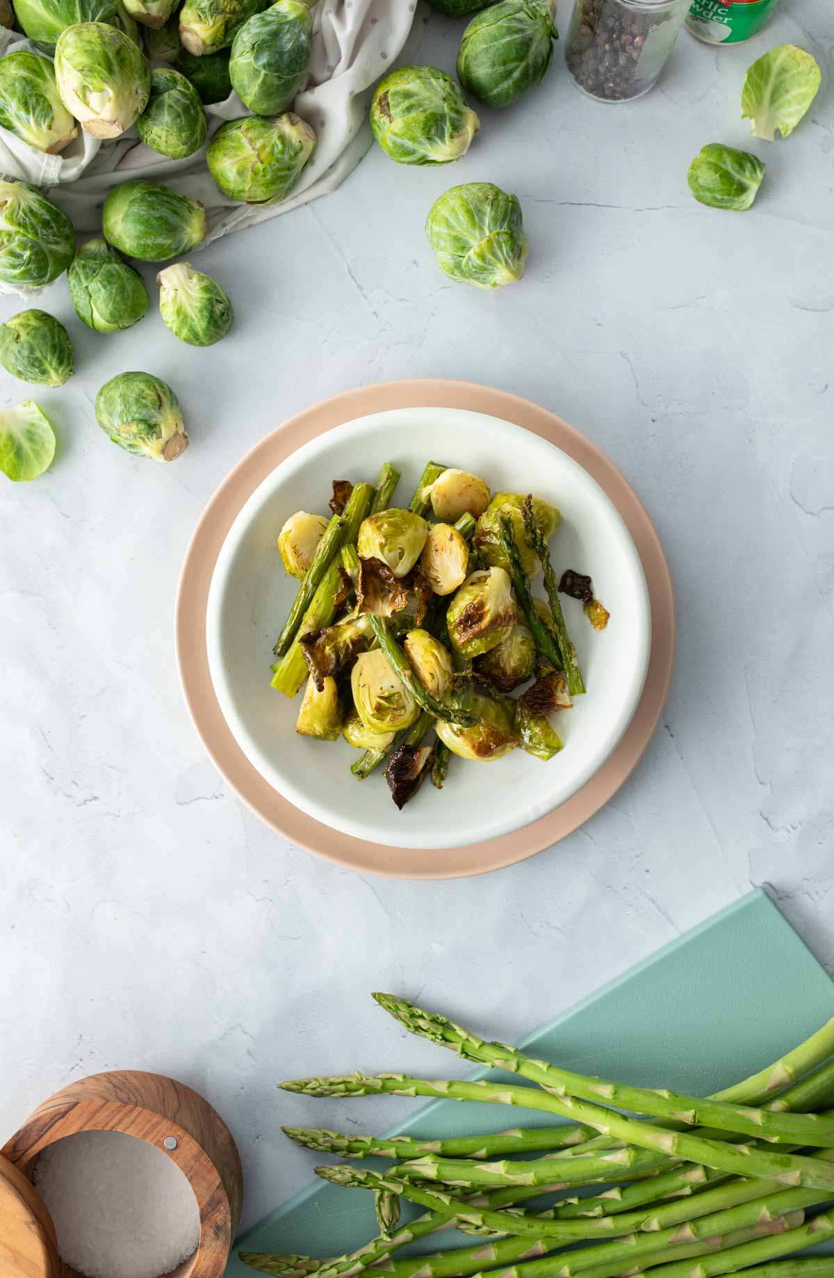 plate of brussels sprouts and asparagus with ingredients around it