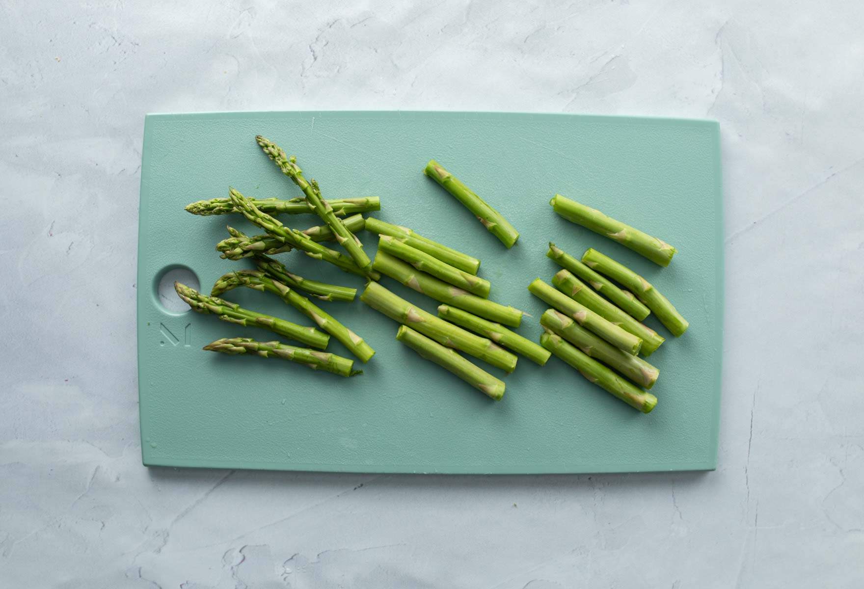 cut asparagus spears on cutting board
