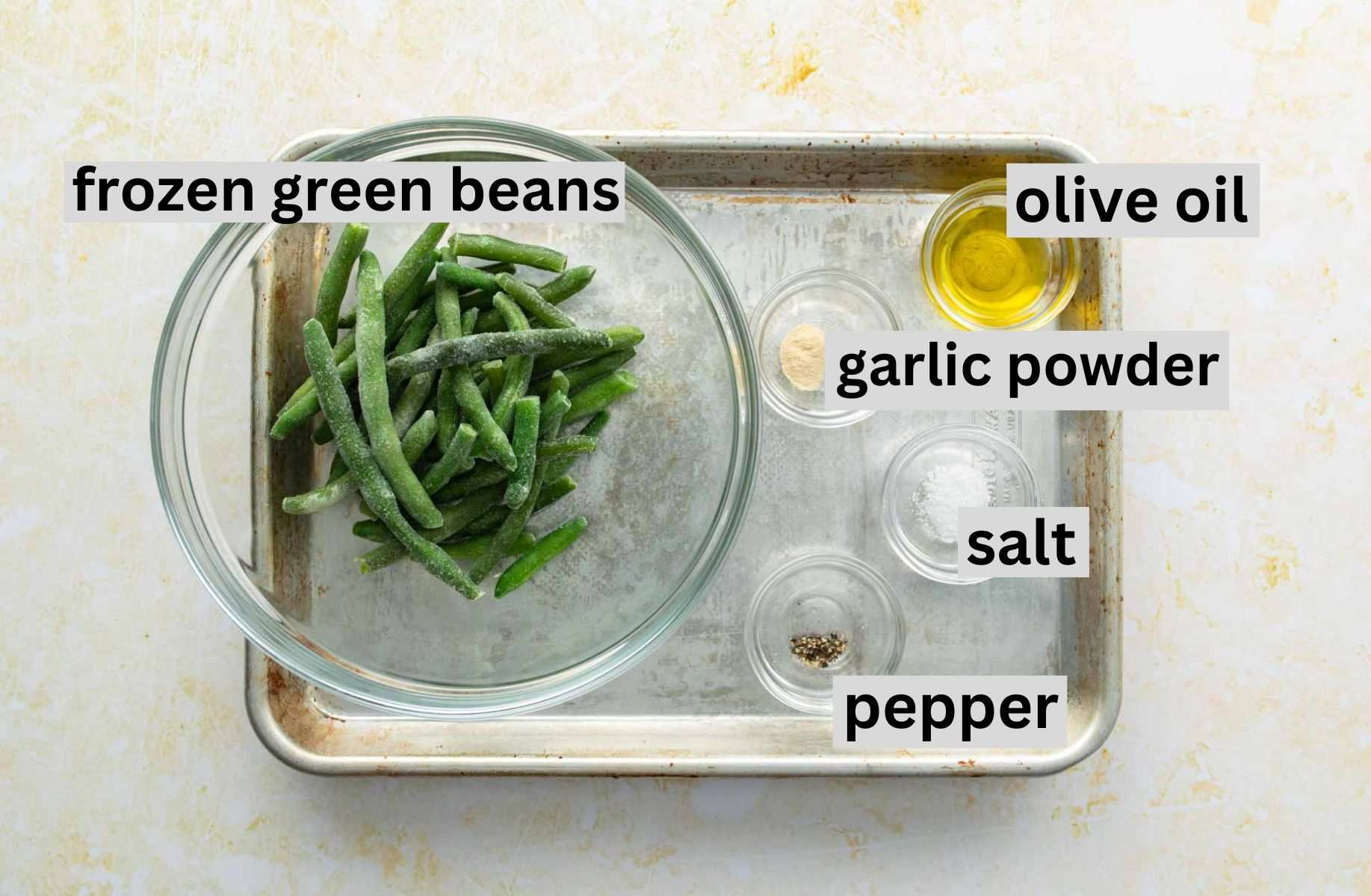 frozen green beans, seasonings on baking sheet with ingredient labels