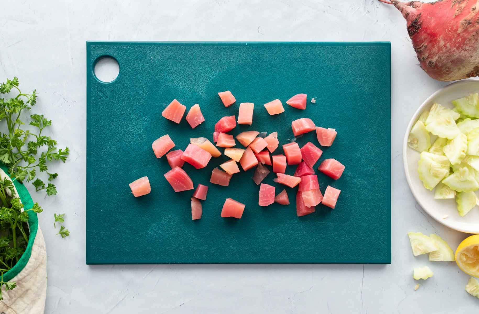 chopped pink beets on green cutting board