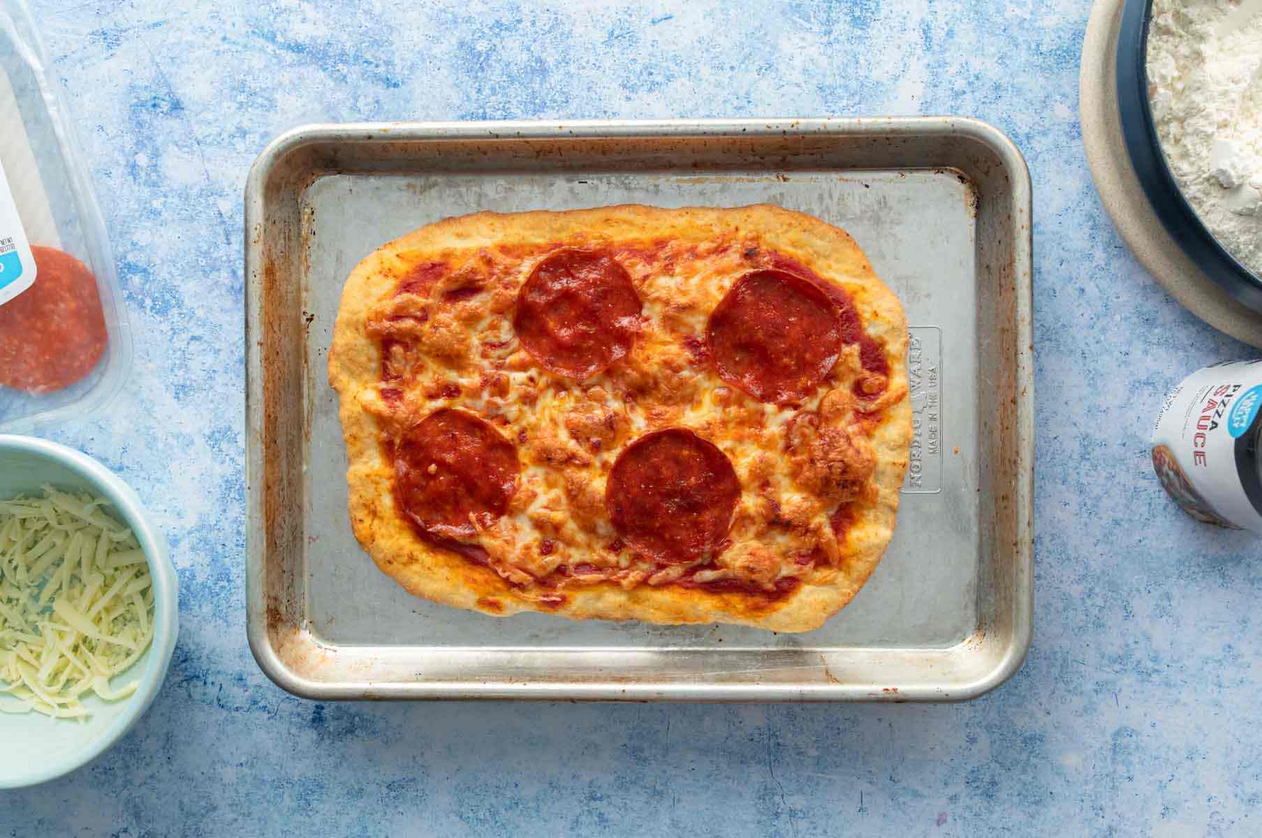 cooked rectangular pepperoni pizza on pan