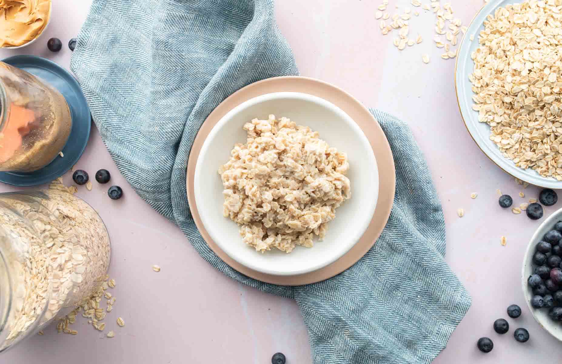 plain oatmeal in bowl with ingredients around it