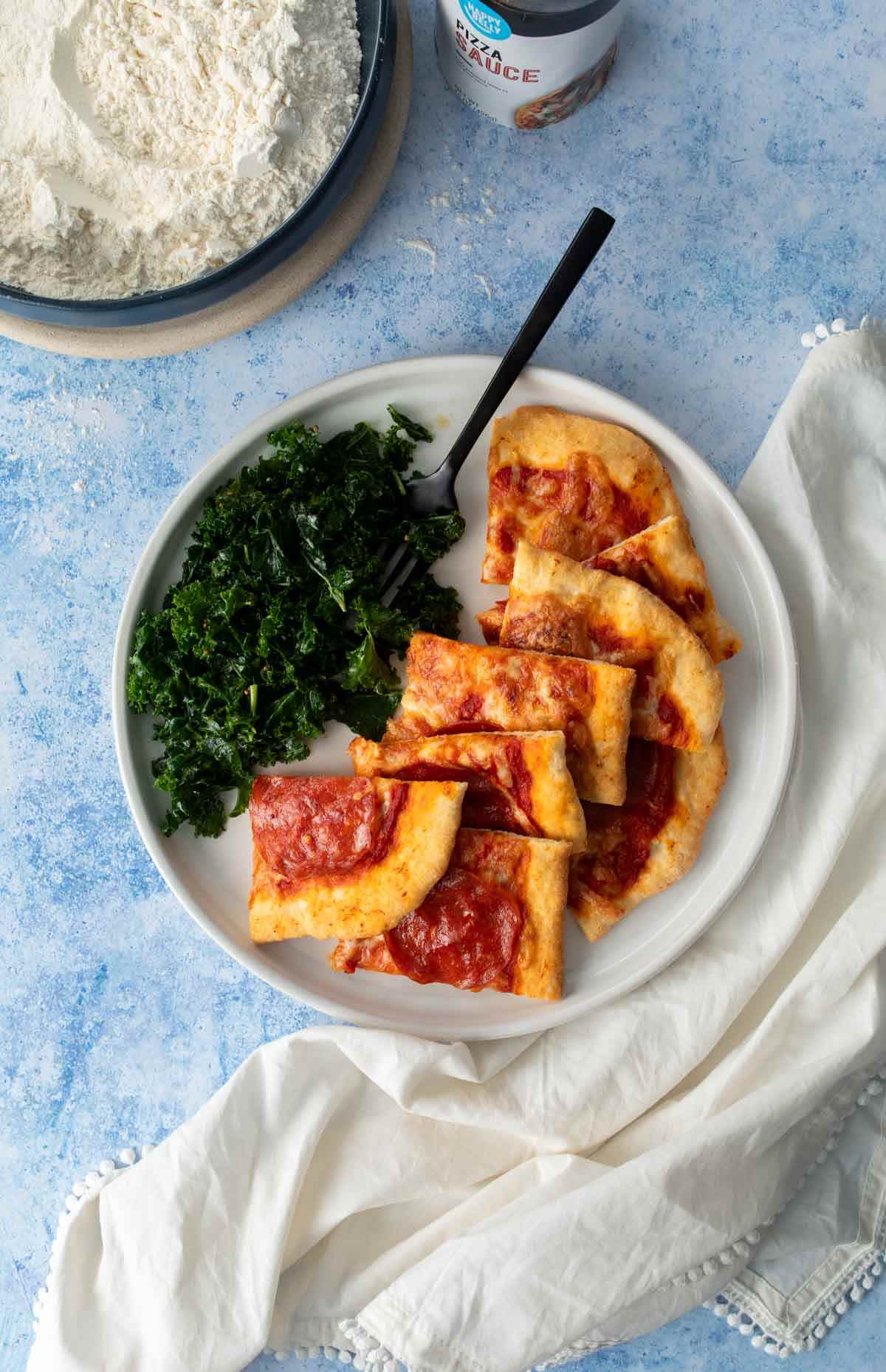 pepperoni pizza slices and kale salad on plate