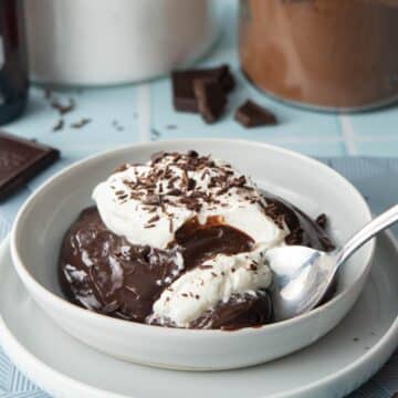 spoonful of chocolate pudding with whipped cream and chocolate shavings