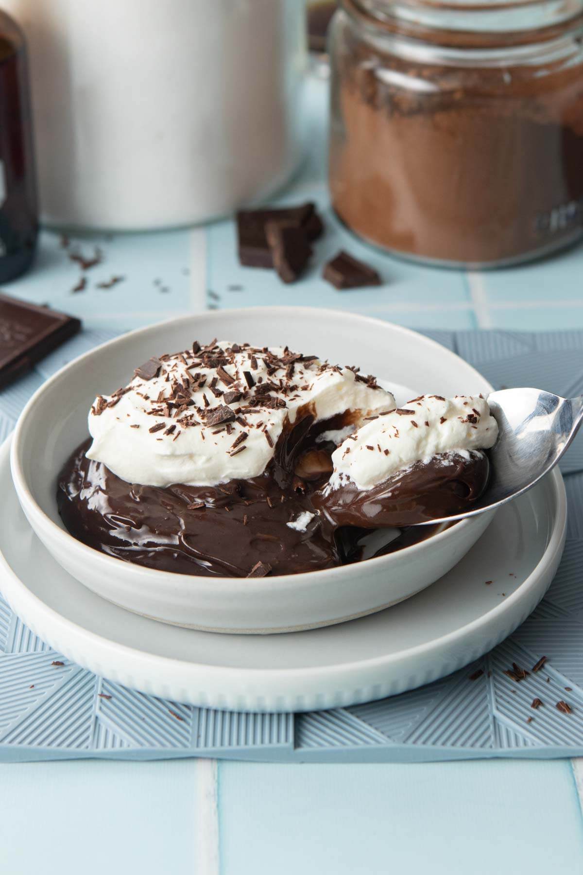bowl of chocolate pudding with toppings, spoonful on the side