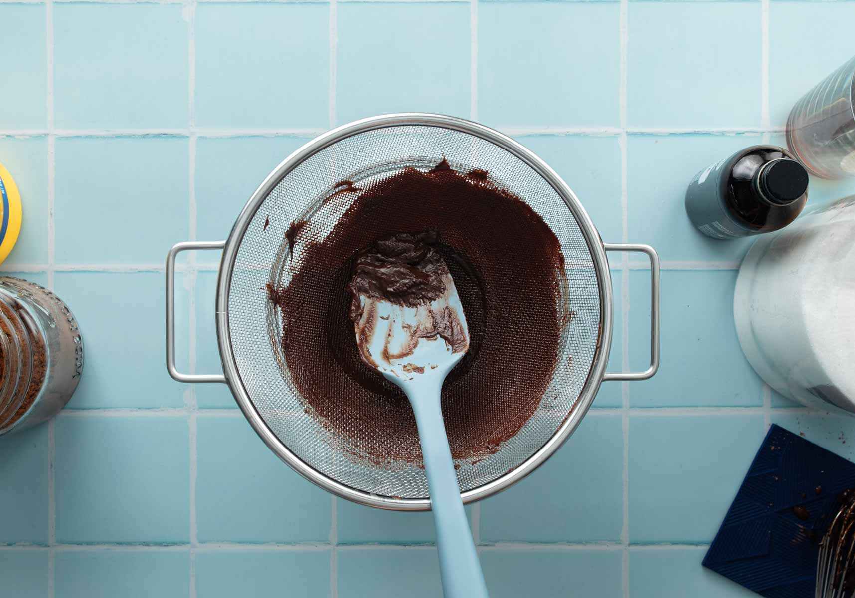 straining chocolate pudding with blue spoon